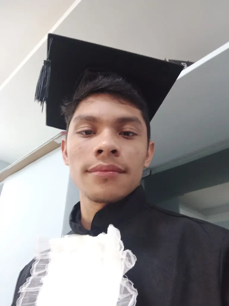 Image of Emanuel Pires with degree clothes and a hat